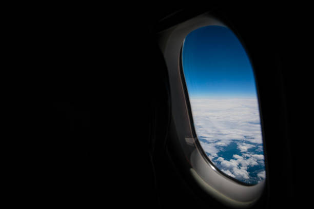 vista dal finestrino dell'aeromobile. vista cielo nuvoloso dalla finestra dell'aereo sugli apl austriaci. - window porthole sky cloudscape foto e immagini stock