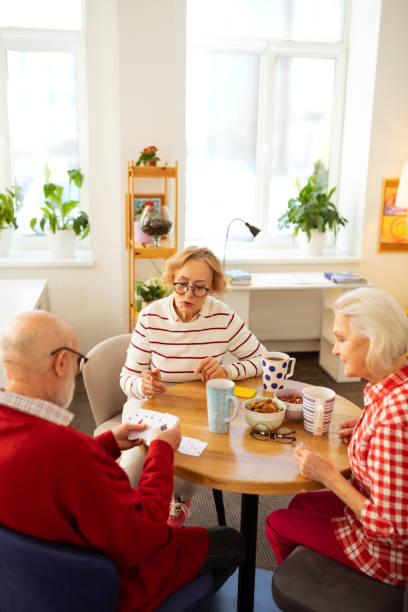 istock Nice pleasant aged people playing cards together 1148246401