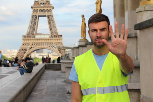 мужчина в желтых жилетах протестует в париже, франция - protestor protest sign yellow стоковые фото и изображения