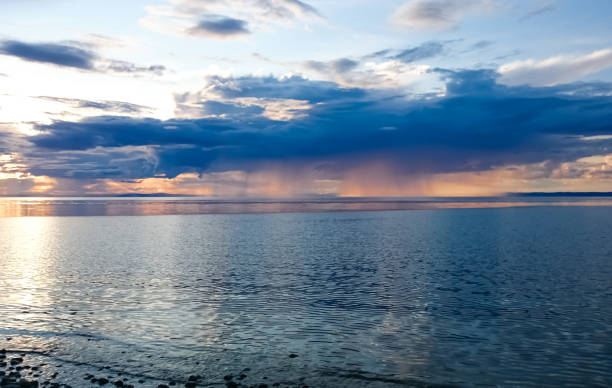 istock Sunset on Lake Baikal. Evening, rain, clouds, sun. Dramatic sky. Atmospheric landscape. The shore of Lake Baikal. 1148250766