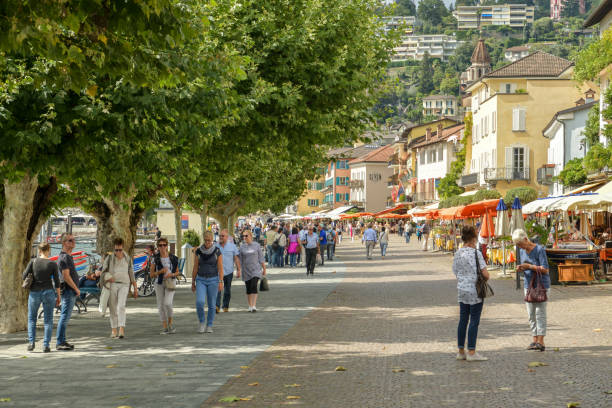 people walking through promenade next to lake maggiore in ascona, switzerland - tessin imagens e fotografias de stock