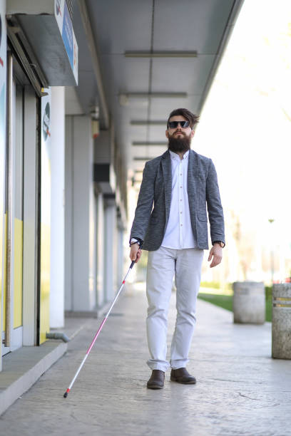 istock Blind and bearded man with a walking stick on the street 1148252711