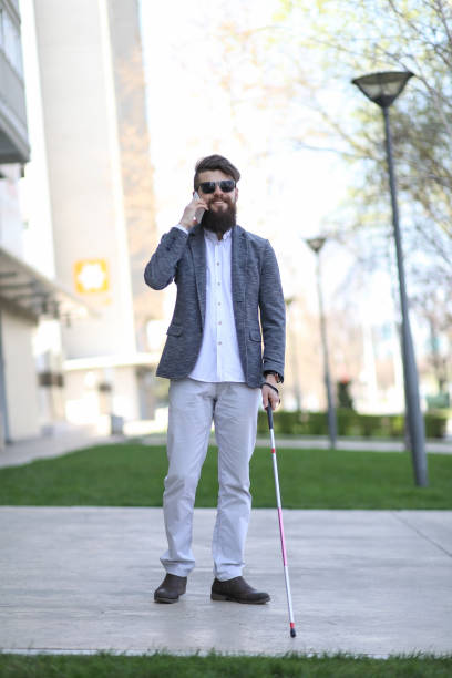 istock Blind and bearded man with a walking stick on the street 1148252727