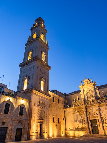 Lecce, Italy - August 15, 2018: Tower bell of the Catholic cathedral in Piazza Del Duomo square of Lecce in evening lights
