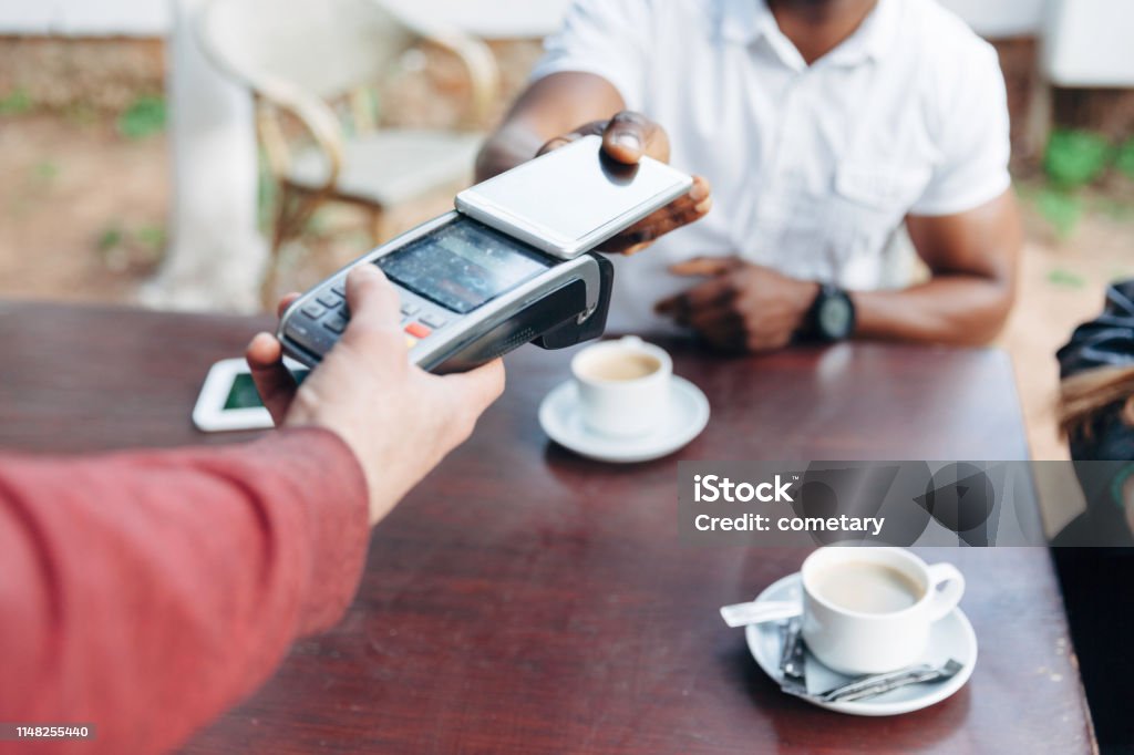 スマートフォンとの非接触を払ってカフェでビジネスマン - スマートフォンのロイヤリティフリーストックフォト