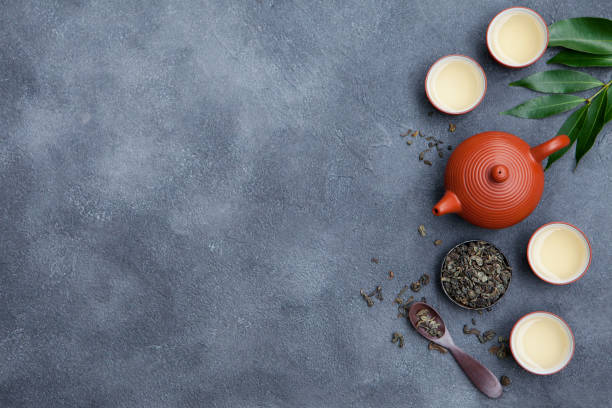 istock Green tea in tea pot and chawan bowls, cups on slate background. Top view. Copy space. 1148257590