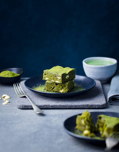 Matcha green tea cake, bars, brownie with white chocolate on a plate. Grey stone background. Copy space. Matcha green tea cake, bars, brownie with white chocolate on a plate. Grey stone background. Copy space chlorella stock pictures, royalty-free photos & images