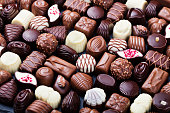 Assortment of fine chocolate candies, white, dark, and milk chocolate. Sweets background.