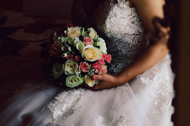 istock Bride sitting on bed and holding flowers 1148258779