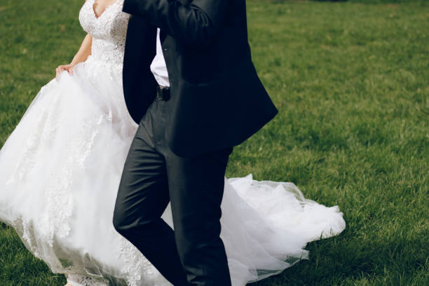 istock Bride and groom walking on green grass 1148258785
