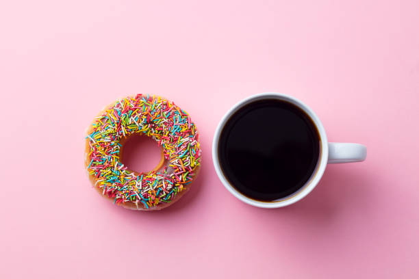 istock Coffee with donut on pink paper background. Top view. Copy space. 1148260228