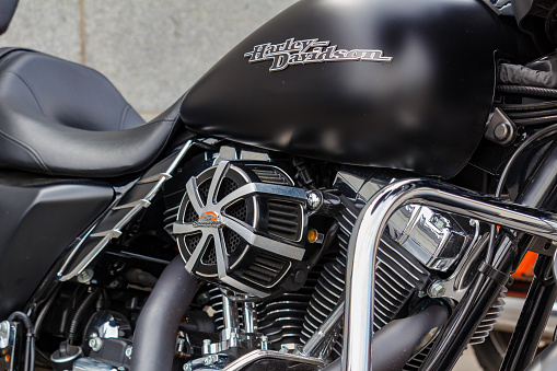Moscow, Russia - May 04, 2019: Matte black fuel tank with Harley Davidson motorcycles emblem and chrome engine closeup. Moto festival MosMotoFest 2019