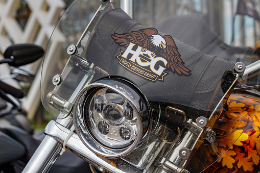 Moscow, Russia - May 04, 2019: Emblem of Harley Owners Group on transparent windproof shield of Harley Davidson motorcycle. Moto festival MosMotoFest 2019