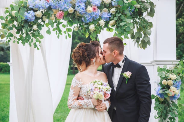 istock Young beautiful couple kissing at wedding reception 1148264539