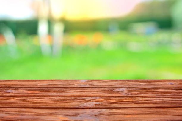 istock Table top background. Wooden table for your montage or design with a green nature on a back drop. 1148264547