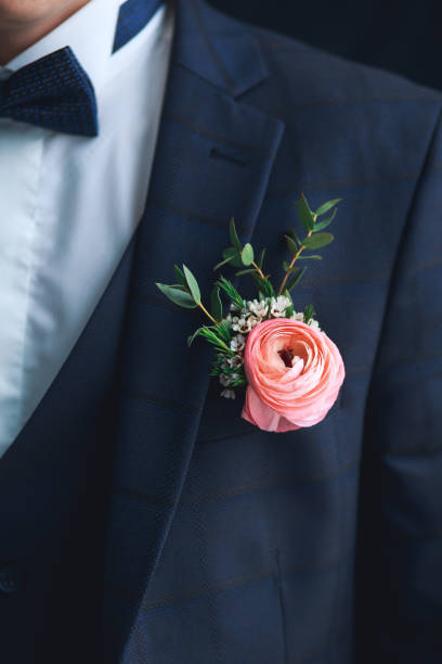 крупным планом розовый ranunculus boutonniere на жениха - boutonniere стоковые фото и изображения