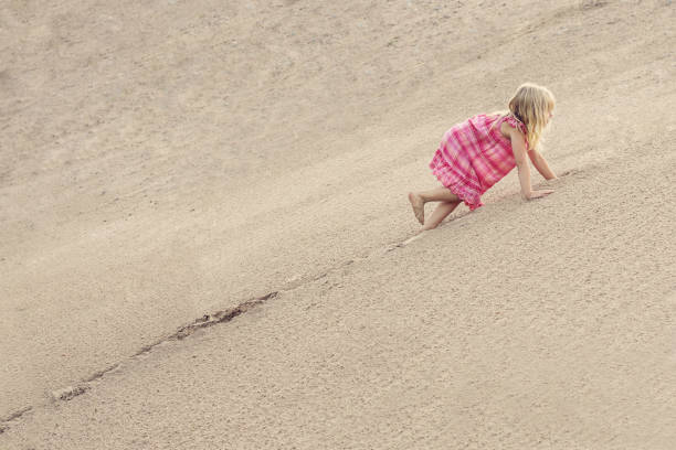 istock Girl Climbing On The Sand dune. Summer day 1148272178