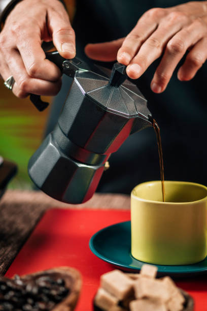 istock Pouring Coffee From A Black Matte Stovetop Moka Pot 1148276016