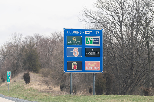 Harrisburg, USA - April 6, 2018: Rural Pennsylvania countryside in spring with blue exit sign on highway for lodging with la quinta, motel 6 and econolodge