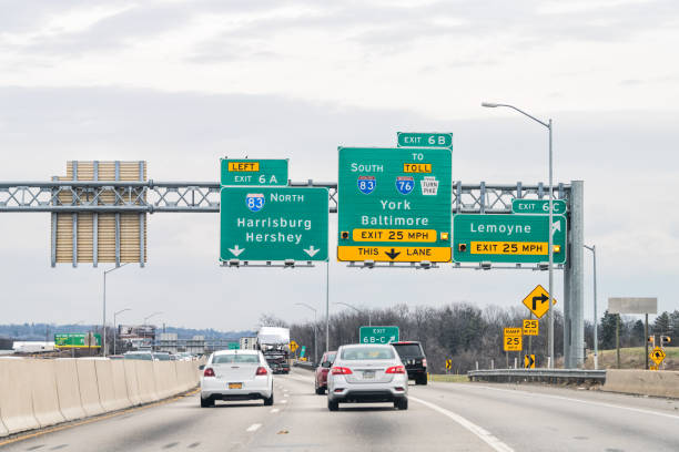 signe de sortie sur l’autoroute 83 nord en pennsylvanie avec le trafic de voitures pour hershey, york et baltimore - sign street traffic left handed photos et images de collection