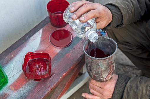 The master who paints the car prepares a suitable mixture of paint for painting in a bowl.