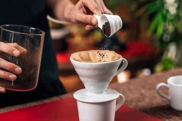 コーヒーのフィルター。挽いたコーヒーを手動ドリップコーヒーメーカーに注ぐ - cup coffee pot coffee coffee cup ストックフォトと画像