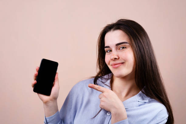 istock woman with smart phone pointing on blank screen 1148278353