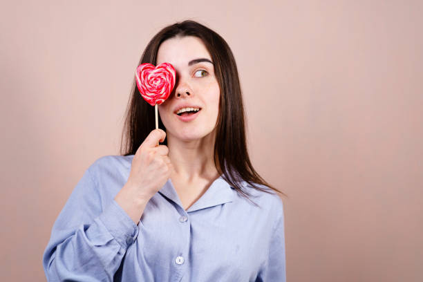 istock Cute woman having fun with heart shaped lollipop 1148278370