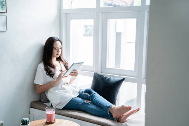 istock woman using her gadget while sitting in cafe 1148280517