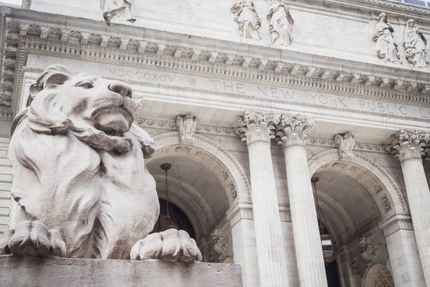 Monumental entry of The New York Public Library with the statue of the lion truncating and watching passersby stock photo