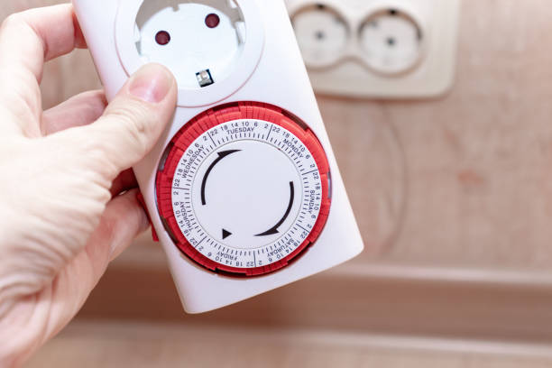 istock 24 Hour 7 days a week mains plug in timer switch european socket for energy and money saving in the hand, blurred socket on background 1148286242
