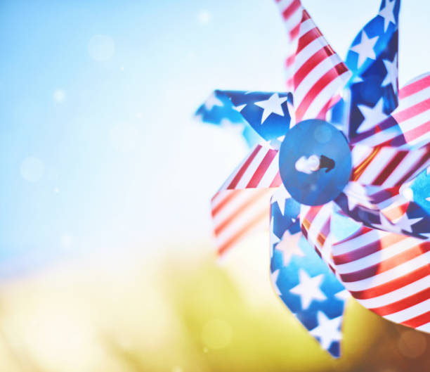 Patriotic pinwheel spinning in summer sunshine Patriotic pinwheel spinning in summer sunshine fourth of july photos stock pictures, royalty-free photos & images