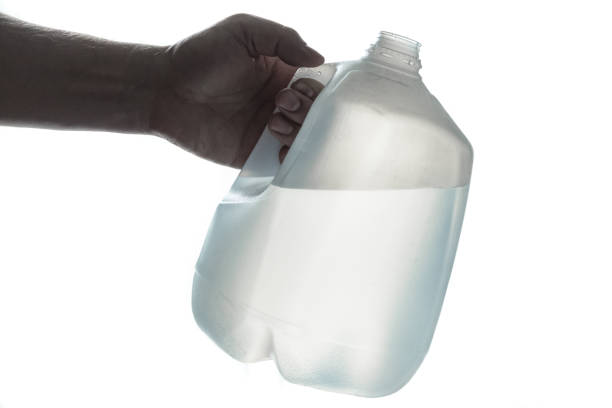 hand hält 1 gallone plastikflasche trinkwasser - gallone stock-fotos und bilder