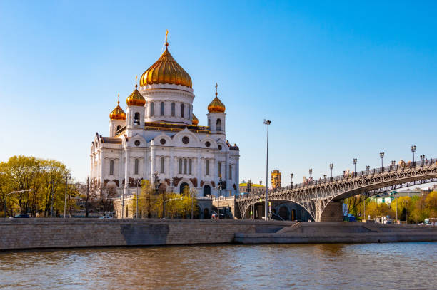 cathedral of christ the savior and patriarchal bridge over the river in moscow, russia. russian orthodox church in sunny spring day and blue sky in the background - patriarchal cross imagens e fotografias de stock