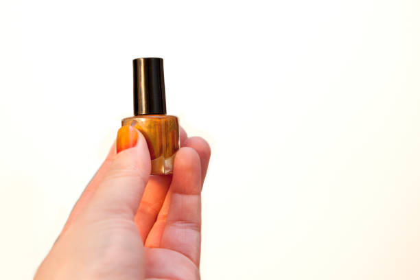 istock Hand holds bottle of orange nail polish 1148295914