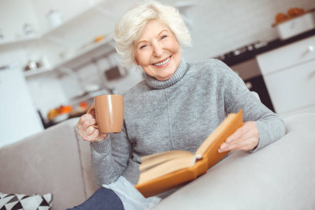 istock Happiness elderly woman reads the book and drinks coffee 1148298177