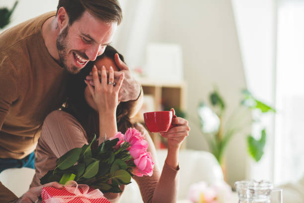 Man surprising his girlfriend with flowers