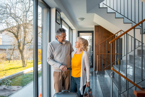 istock Senior couple affectionately standing in the hall with a suitcase 1148298465