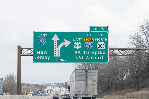 Breiningsville, USA - April 6, 2018: Exit sign on highway 78 east in Pennsylvania with cars traffic on cloudy day for New Jersey