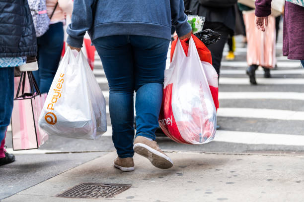 manhattan, new york city con donna che cammina e porta scarpe senza pagamento e borse della spesa jcpenney - victorias secret shopping bag pink photography foto e immagini stock