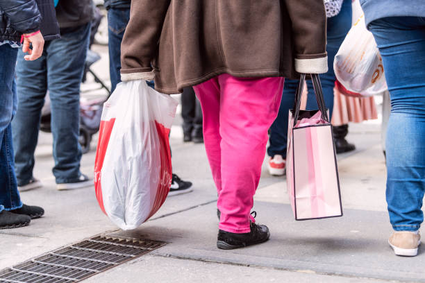 donna che si incassa con jcpenney e la borsa della spesa victoria's secret a manhattan, new york city sulla 6th avenue - victorias secret shopping bag pink photography foto e immagini stock