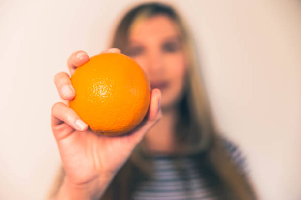 istock Woman holding orange fruit 1148301511