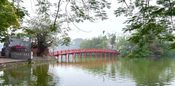 istock Architectural Huc Bridge looming shake trees lake 1148309583