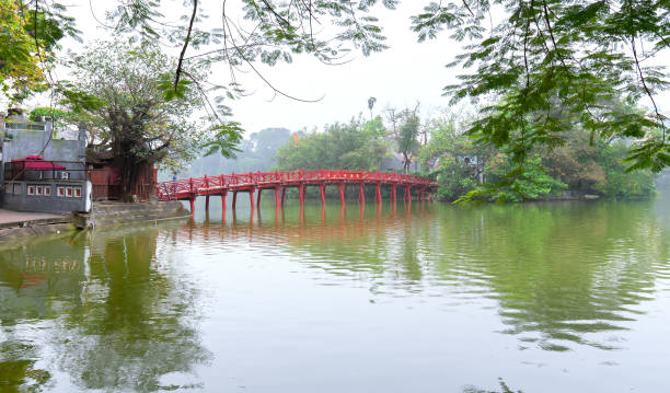 istock Architectural Huc Bridge looming shake trees lake 1148309595