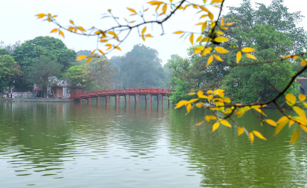 istock Architectural Huc Bridge looming shake trees lake 1148309598