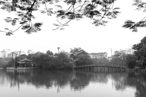 istock Architectural Huc Bridge looming shake trees lake 1148309608