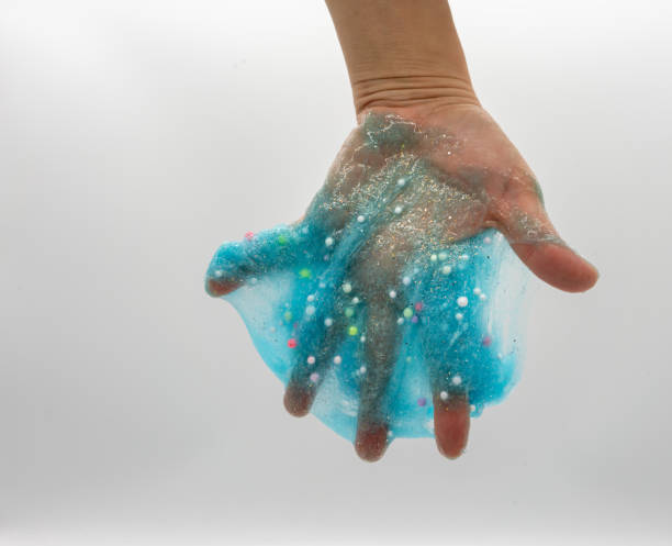 istock Hand playing or soaking transparent blue glitter slime isolated on white background 1148317936