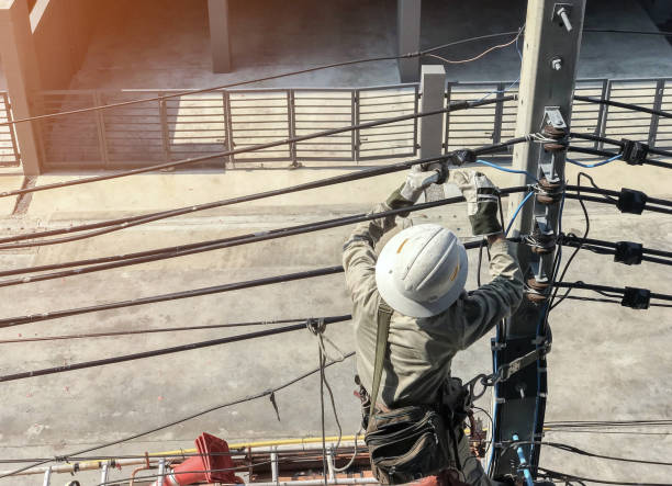 los electricistas suben en postes eléctricos - maintenance engineer fotografías e imágenes de stock