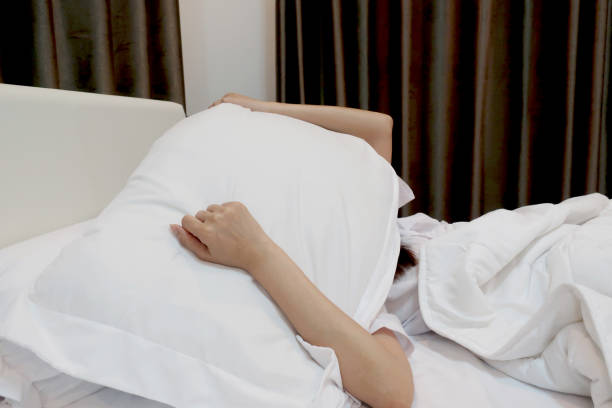 istock women cover her head by pillow on the bed 1148325368
