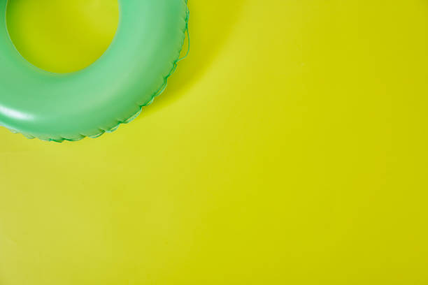 grüner aufblasbarer ring auf gelbem hintergrund. raum für text. - inner tube inflatable isolated toy stock-fotos und bilder